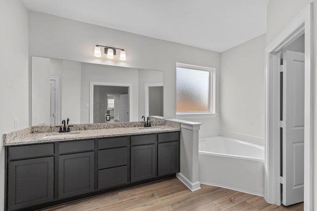 3122 Banyan Dr, Texas City, TX 77510 - bathroom featuring double vanity, a bath, and wood finished floors