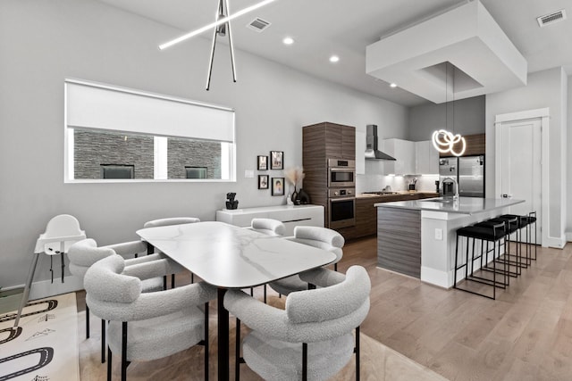 1617 Wheeler St Unit C, Houston, TX 77004 - dining room with a chandelier, light wood-type flooring, recessed lighting, and a towering ceiling