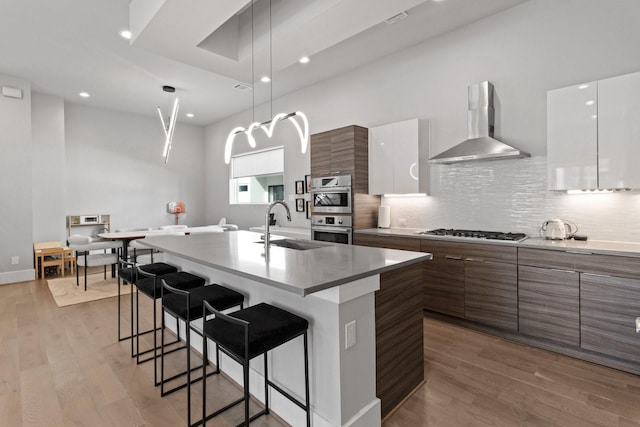 1617 Wheeler St Unit C, Houston, TX 77004 - kitchen featuring wall chimney range hood, modern cabinets, a breakfast bar area, backsplash, and recessed lighting
