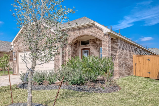 1452 Sundown Glen Ln, Katy, TX 77493 - view of front of home with brick siding, an attached garage, driveway, a front lawn, and a shingled roof
