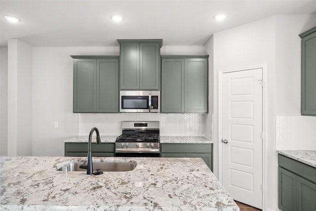 1468 Sundown Glen Dr, Katy, TX 77493 - kitchen with appliances with stainless steel finishes, decorative backsplash, light stone counters, recessed lighting, and wood finished floors