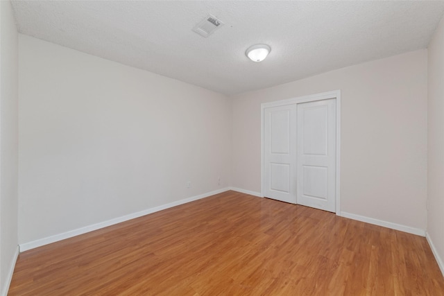 12606 Wellington Park Dr, Houston, TX 77072 - unfurnished bedroom featuring light wood finished floors, a closet, and a textured ceiling