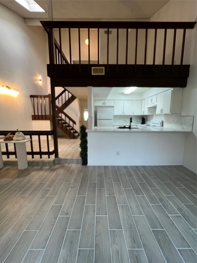 12922 Wirevine Ln, Houston, TX 77072 - kitchen featuring white appliances, wood tiled floors, white cabinets, and light countertops