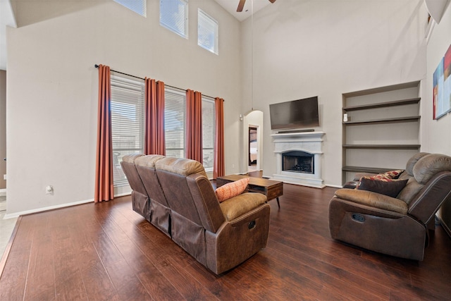 4314 Walden Terrace Ln, Humble, TX 77396 - living room featuring a towering ceiling, ceiling fan, wood-type flooring, a fireplace with raised hearth, and arched walkways