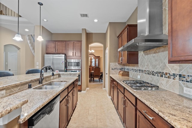 4314 Walden Terrace Ln, Humble, TX 77396 - kitchen with arched walkways, appliances with stainless steel finishes, wall chimney exhaust hood, pendant lighting, and decorative backsplash
