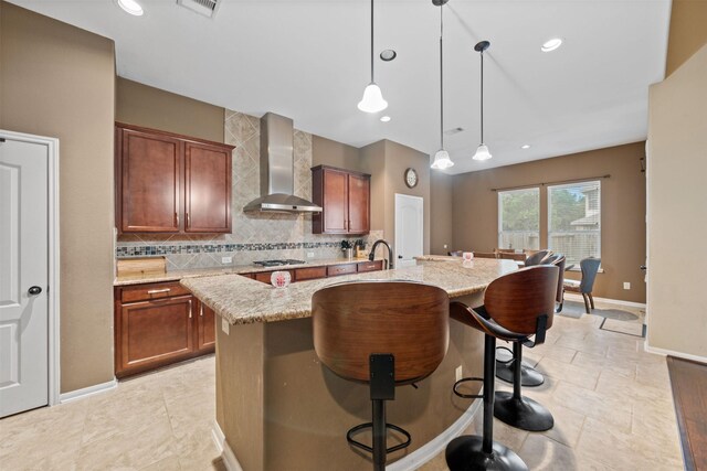 4314 Walden Terrace Ln, Humble, TX 77396 - kitchen featuring wall chimney exhaust hood, an island with sink, backsplash, light stone countertops, and recessed lighting