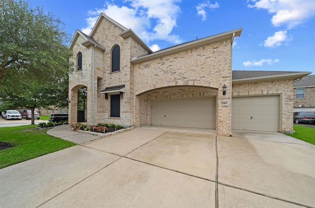 4314 Walden Terrace Ln, Humble, TX 77396 - french provincial home featuring an attached garage, concrete driveway, brick siding, and a front lawn