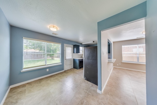 12511 Garden Gale Ln, Houston, TX 77044 - kitchen featuring plenty of natural light, a textured ceiling, light countertops, and light tile patterned floors