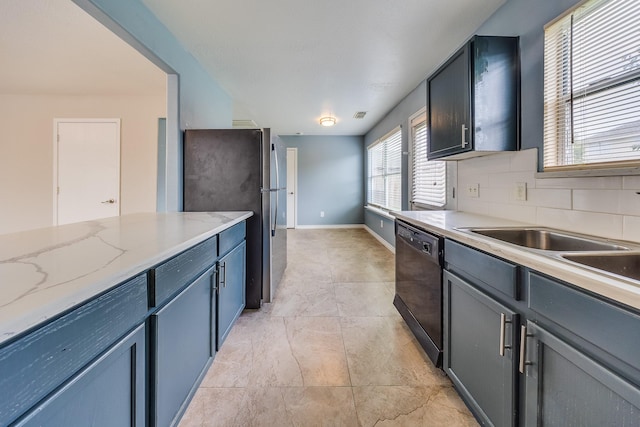 12511 Garden Gale Ln, Houston, TX 77044 - kitchen featuring black dishwasher, freestanding refrigerator, tasteful backsplash, and light stone countertops