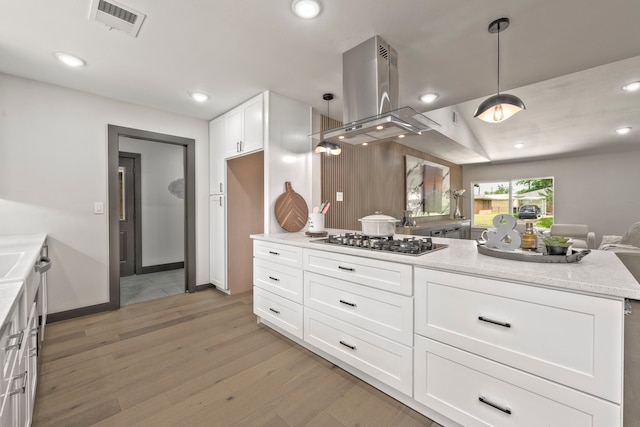 5425 Viking Dr, Houston, TX 77092 - kitchen featuring stainless steel gas stovetop, light wood-style flooring, open floor plan, island exhaust hood, and white cabinets