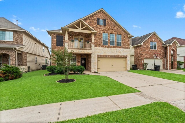 30742 Gardenia Trace Dr, Spring, TX 77386 - view of front of home featuring a balcony, driveway, an attached garage, brick siding, and a front yard