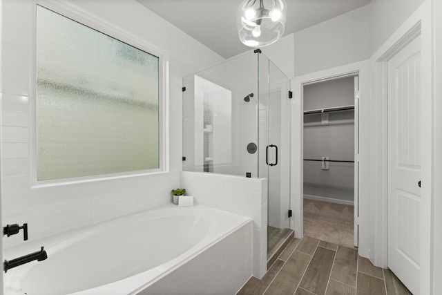 30742 Gardenia Trace Dr, Spring, TX 77386 - bathroom featuring a garden tub, a shower stall, a spacious closet, and wood finish floors