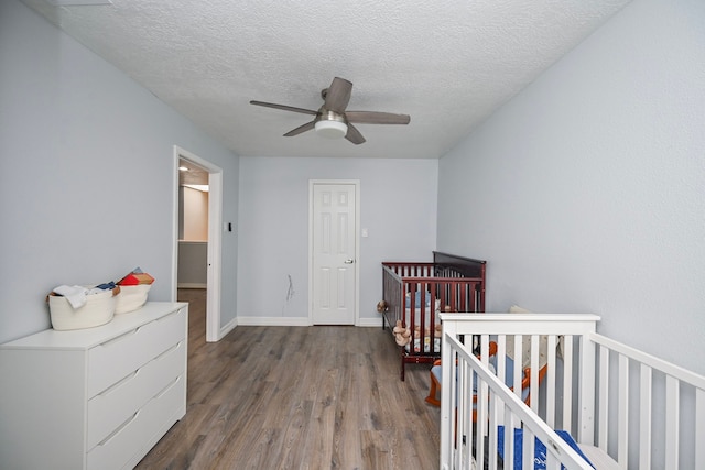 11811 Braesridge Dr, Houston, TX 77071 - bedroom with wood finished floors, a textured ceiling, a nursery area, and ceiling fan