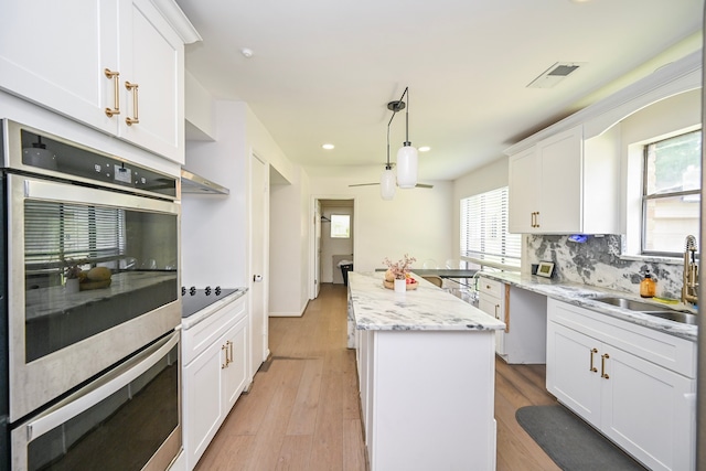 11811 Braesridge Dr, Houston, TX 77071 - kitchen featuring a center island, stainless steel double oven, decorative backsplash, white cabinetry, and recessed lighting
