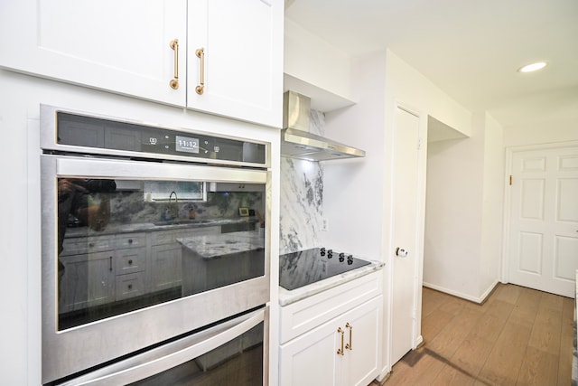 11811 Braesridge Dr, Houston, TX 77071 - kitchen featuring wall chimney exhaust hood, black electric stovetop, decorative backsplash, white cabinetry, and light wood-type flooring