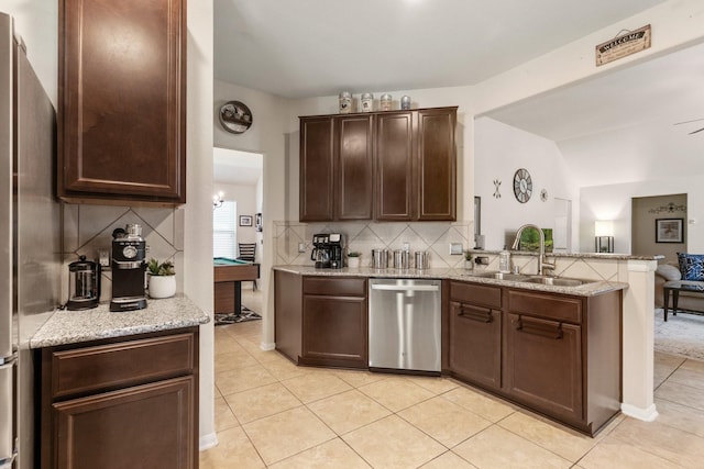 15006 Zenith Glen Ln, Cypress, TX 77429 - kitchen with stainless steel appliances, light tile patterned flooring, backsplash, a peninsula, and dark brown cabinetry