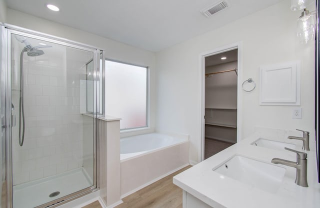 17515 Prospect Meadows Dr, Houston, TX 77095 - bathroom with a shower stall, a garden tub, wood finished floors, double vanity, and recessed lighting