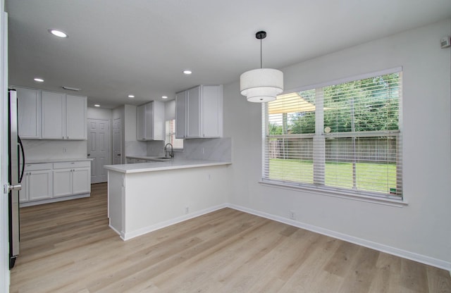 17515 Prospect Meadows Dr, Houston, TX 77095 - kitchen featuring light countertops, a peninsula, plenty of natural light, light wood-style flooring, and recessed lighting