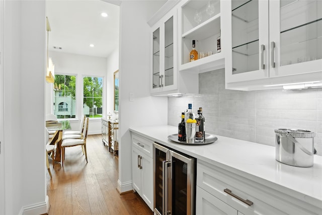 4951 Glenmeadow Dr, Houston, TX 77096 - kitchen featuring wine cooler, white cabinets, dark wood-style floors, tasteful backsplash, and recessed lighting