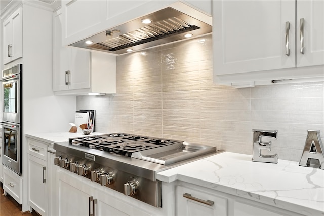 4951 Glenmeadow Dr, Houston, TX 77096 - kitchen with custom exhaust hood, appliances with stainless steel finishes, tasteful backsplash, white cabinetry, and light stone counters