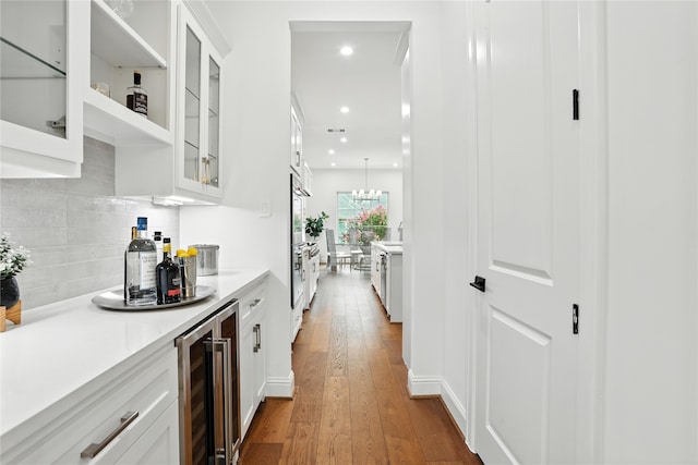 4951 Glenmeadow Dr, Houston, TX 77096 - kitchen with wine cooler, white cabinetry, backsplash, light countertops, and hardwood / wood-style flooring