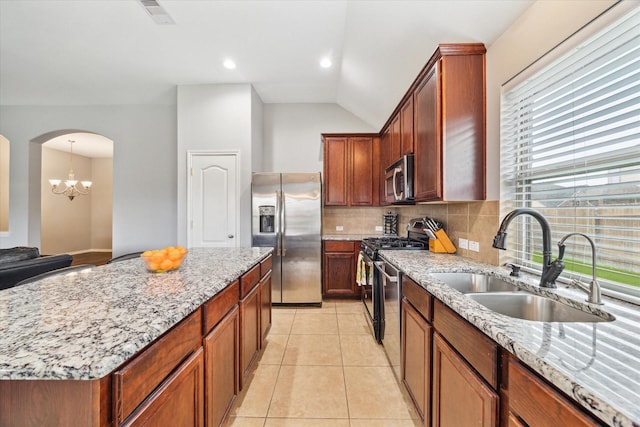 6910 Lamar Park Ln, Houston, TX 77049 - kitchen with stainless steel appliances, light stone countertops, vaulted ceiling, backsplash, and arched walkways