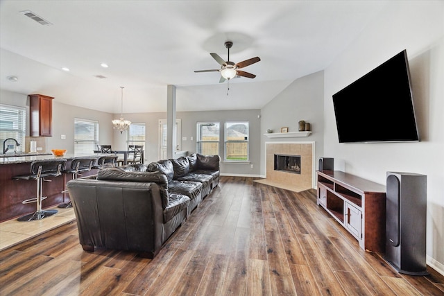 6910 Lamar Park Ln, Houston, TX 77049 - living area with dark wood-style flooring, vaulted ceiling, ceiling fan, a chandelier, and a fireplace