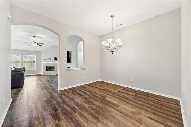 6910 Lamar Park Ln, Houston, TX 77049 - empty room featuring dark wood-type flooring, a ceiling fan, a fireplace, a chandelier, and vaulted ceiling