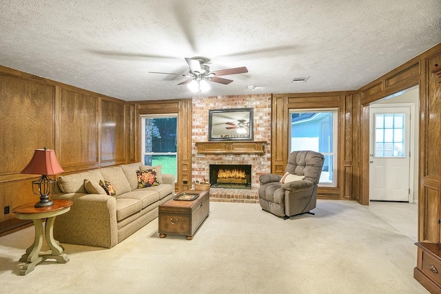 22419 Kent Falls Dr, Katy, TX 77450 - living area with light colored carpet, a fireplace, a ceiling fan, a textured ceiling, and wood walls