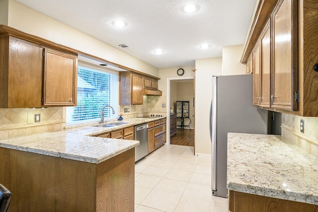 22419 Kent Falls Dr, Katy, TX 77450 - kitchen featuring appliances with stainless steel finishes, a peninsula, tasteful backsplash, and light stone countertops