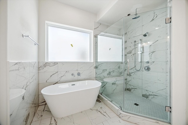 10927 Brookeshire Chase Ln, Houston, TX 77043 - bathroom with a marble finish shower, a freestanding bath, tile walls, marble finish flooring, and a wainscoted wall