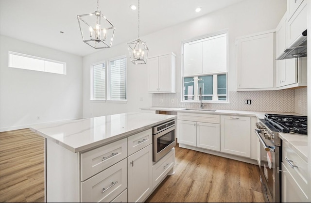 10927 Brookeshire Chase Ln, Houston, TX 77043 - kitchen featuring stainless steel appliances, a chandelier, decorative backsplash, light wood-style flooring, and recessed lighting