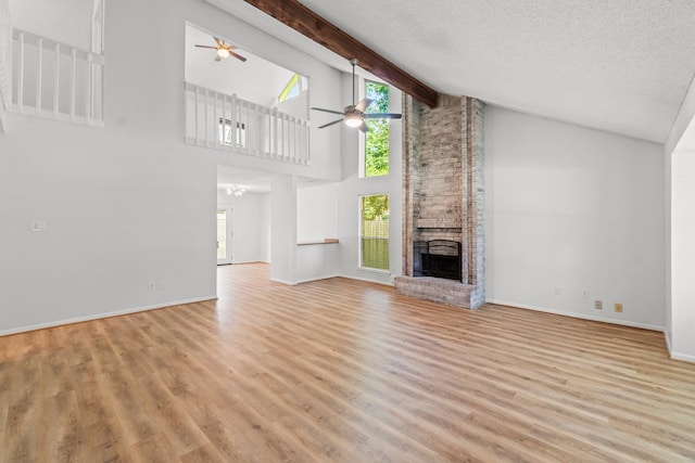 6 Fairmeade Bend Dr, The Woodlands, TX 77381 - unfurnished living room featuring ceiling fan, a brick fireplace, light wood-style flooring, plenty of natural light, and high vaulted ceiling