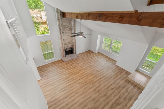 6 Fairmeade Bend Dr, The Woodlands, TX 77381 - unfurnished living room featuring high vaulted ceiling, light wood finished floors, a fireplace, a ceiling fan, and beam ceiling