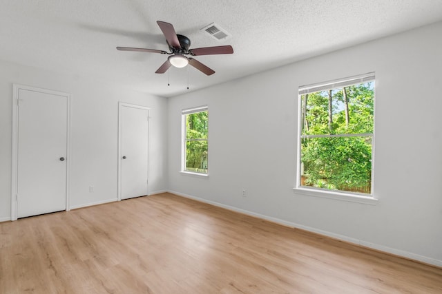 6 Fairmeade Bend Dr, The Woodlands, TX 77381 - unfurnished bedroom with light wood-type flooring, multiple closets, and ceiling fan