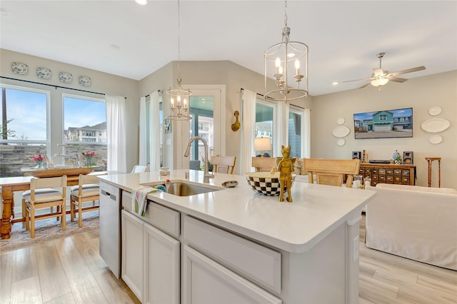 2507 Bay Breeze Dr, Kemah, TX 77565 - kitchen featuring a chandelier, light wood-type flooring, stainless steel dishwasher, an island with sink, and white cabinetry
