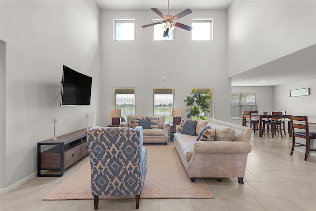 18519 Orono Ridge Trl, Richmond, TX 77407 - living area with a ceiling fan, a towering ceiling, healthy amount of natural light, and light tile patterned floors
