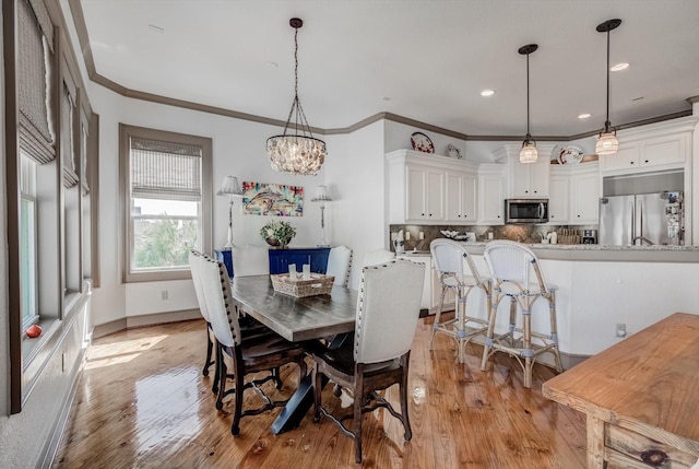 4216 Karankawa Way, Jamaica Beach, TX 77554 - dining space with light wood finished floors, a chandelier, recessed lighting, and crown molding