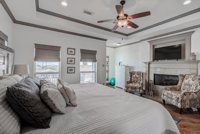 4216 Karankawa Way, Jamaica Beach, TX 77554 - bedroom featuring a high end fireplace, ornamental molding, a raised ceiling, wood finished floors, and recessed lighting