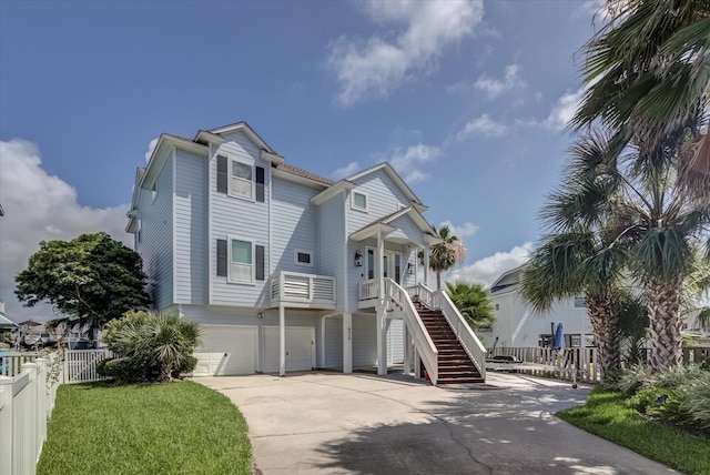 4216 Karankawa Way, Jamaica Beach, TX 77554 - coastal home with stairs, driveway, a garage, and a porch