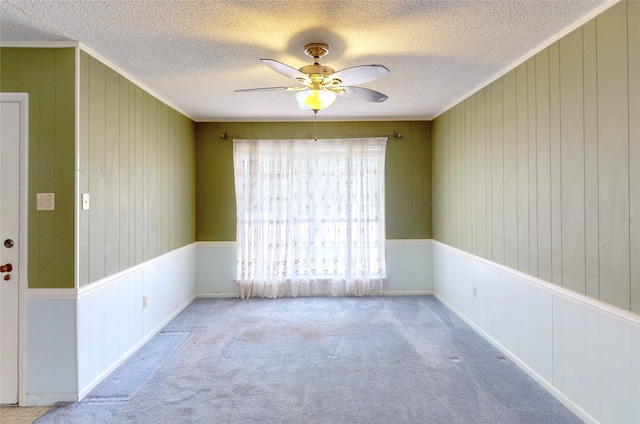 826 Kentucky St, Deer Park, TX 77536 - spare room with a ceiling fan, carpet, a textured ceiling, and wooden walls
