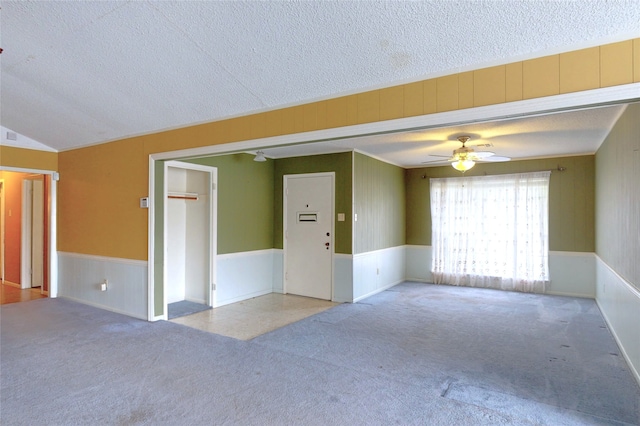 826 Kentucky St, Deer Park, TX 77536 - carpeted spare room with a textured ceiling, a ceiling fan, a wainscoted wall, wooden walls, and lofted ceiling