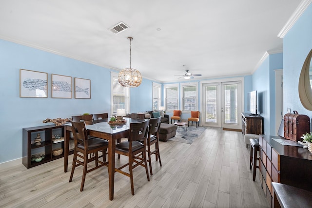 4121 Pointe W Dr Unit 301, Galveston, TX 77554 - dining space featuring crown molding, light wood-style flooring, a ceiling fan, and a chandelier