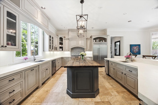 2 Hedwig Shadows Dr, Houston, TX 77024 - kitchen featuring a kitchen island, stone tile flooring, appliances with stainless steel finishes, decorative backsplash, and crown molding
