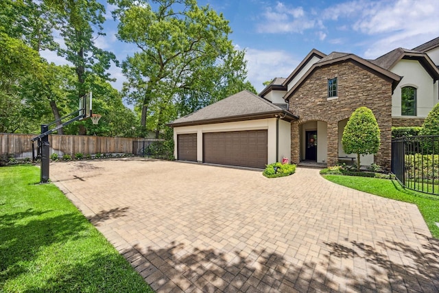 2 Hedwig Shadows Dr, Houston, TX 77024 - view of front of home featuring stucco siding, stone siding, a garage, and decorative driveway