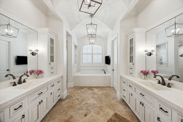 2 Hedwig Shadows Dr, Houston, TX 77024 - full bath featuring a chandelier, two vanities, a garden tub, lofted ceiling, and stone finish floors