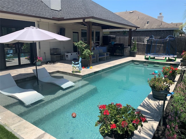 8927 Alcina Dr, Tomball, TX 77375 - view of swimming pool featuring a patio area, a trampoline, and exterior kitchen
