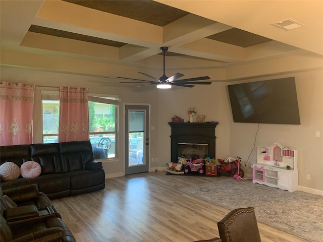 8927 Alcina Dr, Tomball, TX 77375 - living room with coffered ceiling, wood finished floors, a glass covered fireplace, ceiling fan, and beamed ceiling