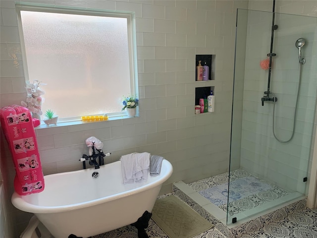 8927 Alcina Dr, Tomball, TX 77375 - bathroom featuring a stall shower, a freestanding bath, and tile walls