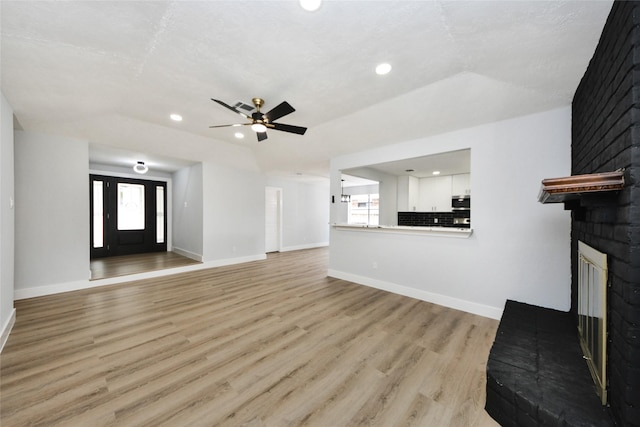10415 Towne Oak Ln, Sugar Land, TX 77498 - unfurnished living room with healthy amount of natural light, recessed lighting, light wood-style floors, a ceiling fan, and a fireplace
